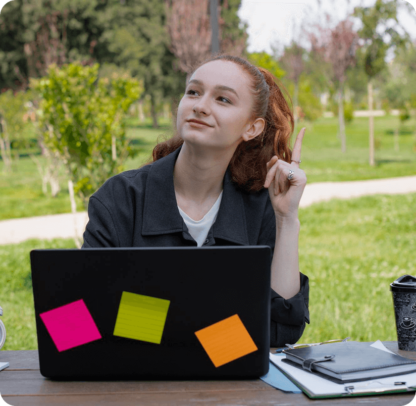 Young woman sitting outdoors with a laptop, smiling thoughtfully, representing data-driven users seeking measurable health improvements